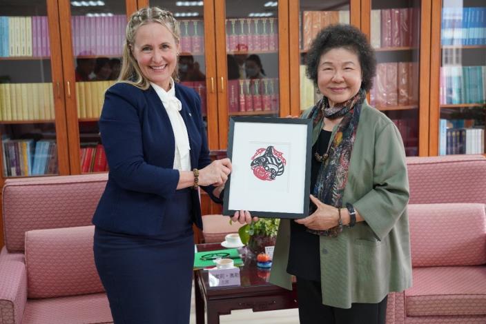 Chair Emily Ohler presents Chairperson Chen Chu with a painting created by a Canadian Indigenous artist