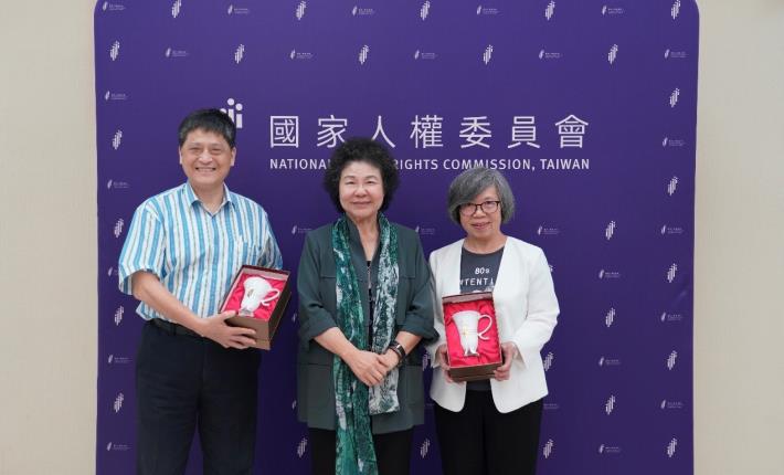 NHRC Chairperson Chen Chu presents an "Embrace Cup," symbolizing the spirit of embracing human rights, to outgoing Commissioners Su Li-chiung and Lai Chen-chang.